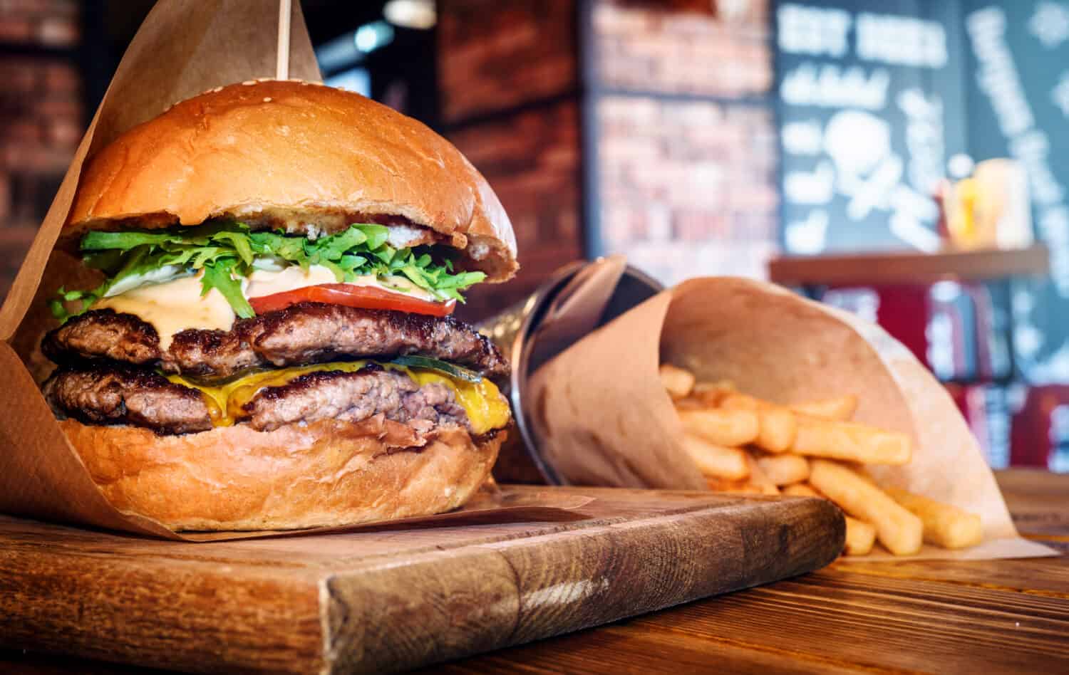 Hamburger fresco e gustoso e patatine fritte sul tavolo di legno