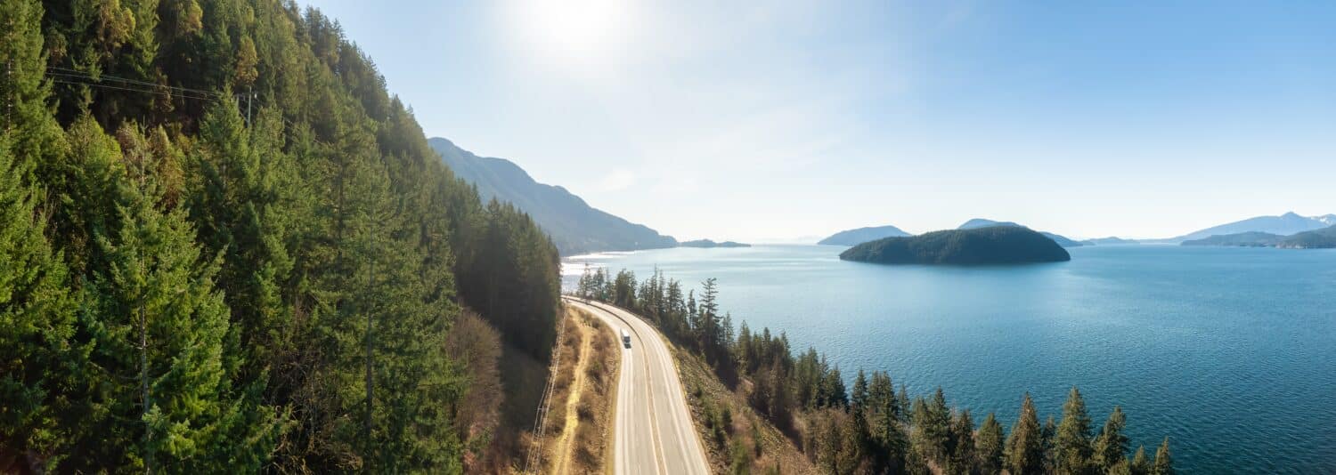 Vista panoramica aerea della Sea to Sky Highway sulla costa occidentale dell'Oceano Pacifico.  Soleggiata giornata invernale.  Situato a Howe Sound tra Vancouver e Squamish, British Columbia, Canada.