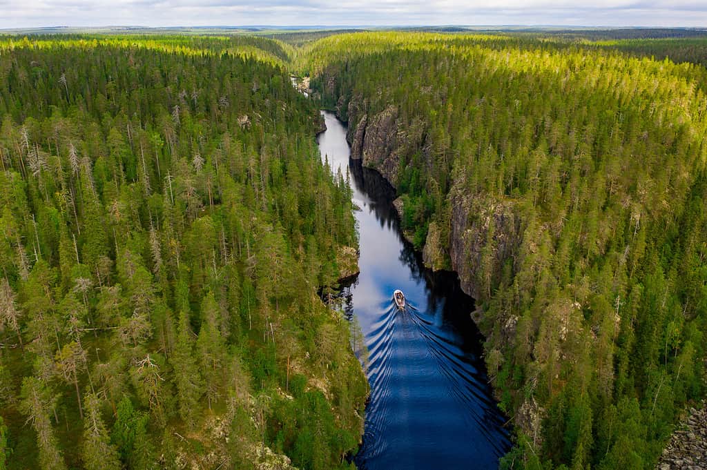 Vista aerea di una barca, di un lago canyon e di una foresta a Julma-Ölkky, Parco nazionale di Hossa, Finlandia