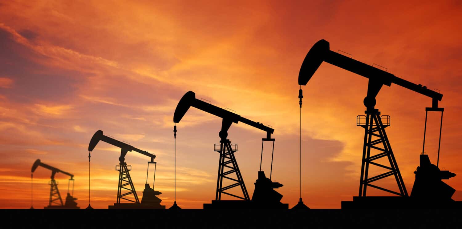 Macchina industriale per l'energia della piattaforma petrolifera della pompa dell'olio per il petrolio sullo sfondo del tramonto per il design