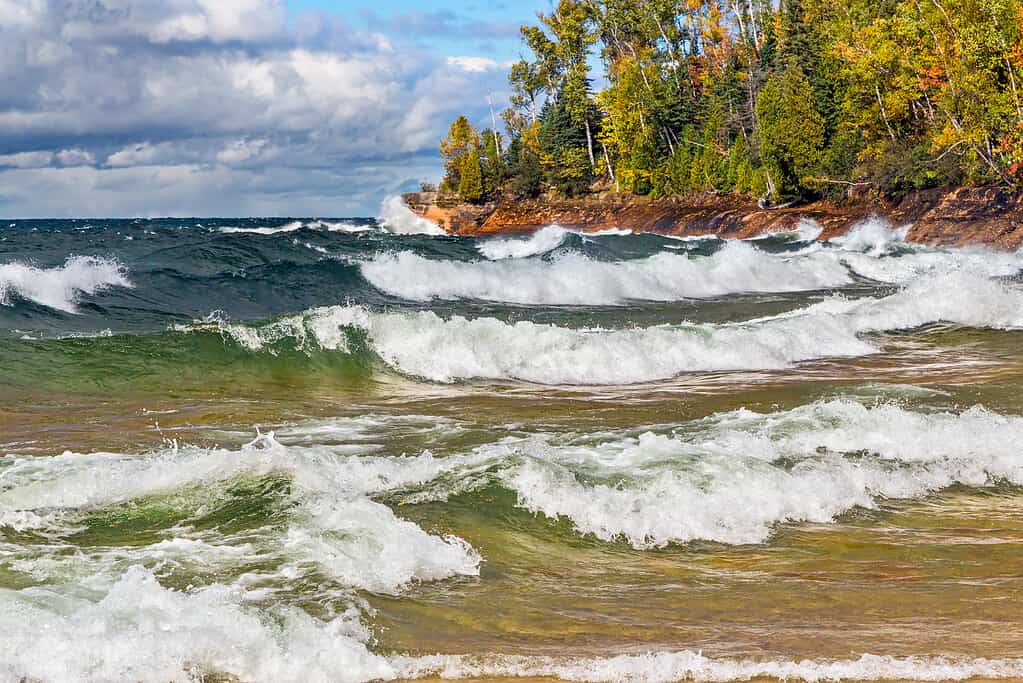 Le onde si infrangono sulla costa rocciosa del Lago Superiore al Pictured Rocks National Lakeshore del Michigan in autunno.  Girato nella penisola superiore del Michigan, non lontano da Munising.