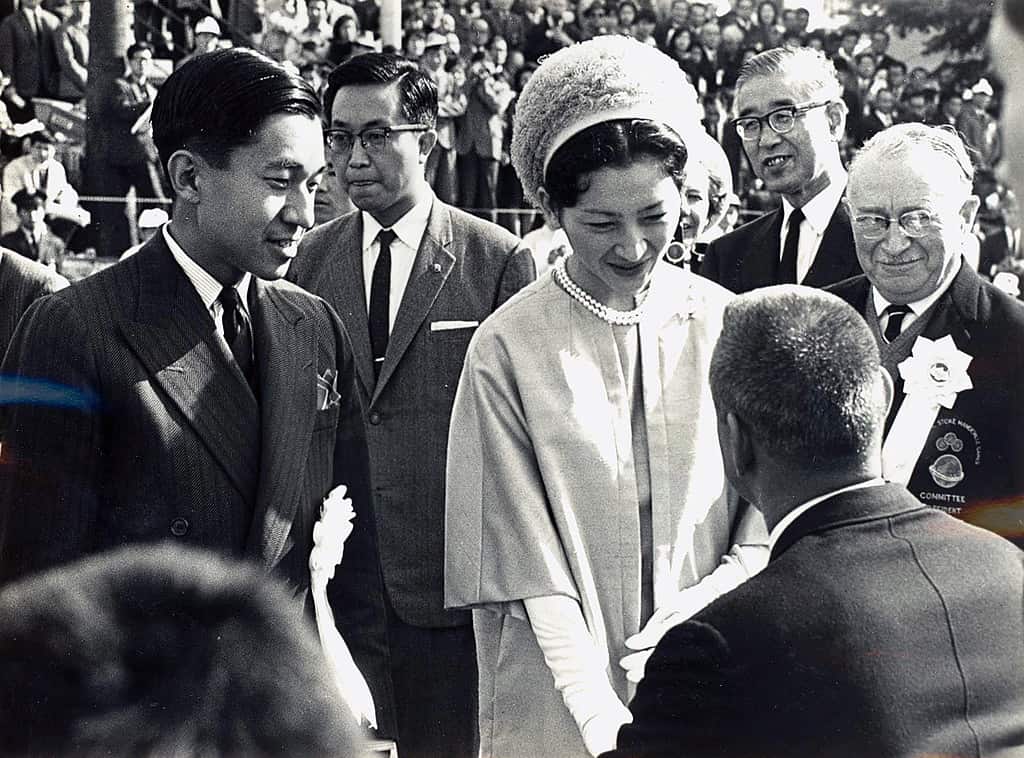 L'imperatrice Michiko e il principe ereditario Akihito (a sinistra) incontrano i rappresentanti delle squadre partecipanti durante la cerimonia di apertura dei Giochi Paralimpici di Tokyo del 1964 sull'Oda Field nel Parco Yoyogi, Tokyo.  A destra dell'immagine c'è Ludwig Guttmann, il fondatore del movimento paralimpico.