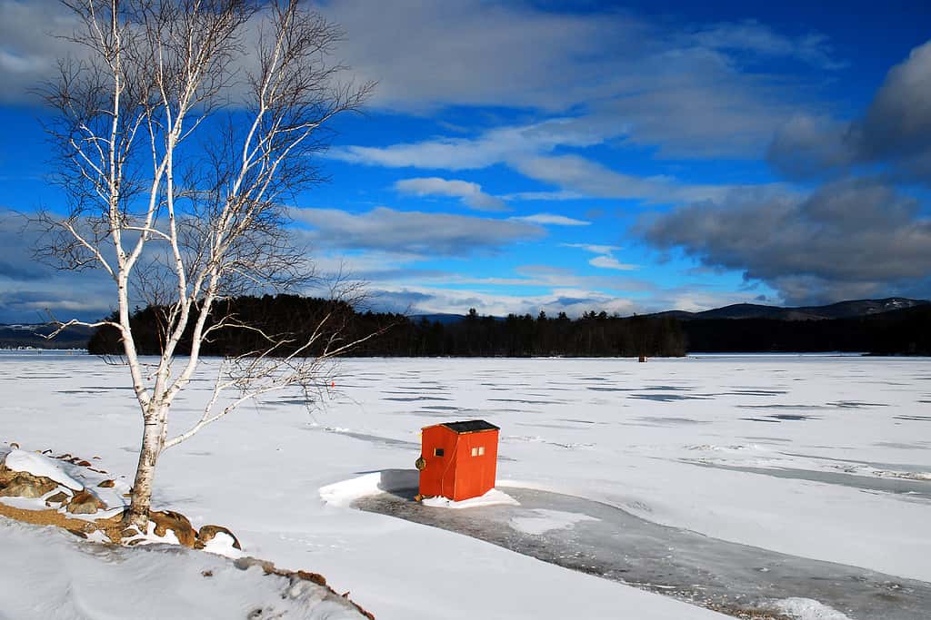 Una baracca solitaria per la pesca sul ghiaccio si trova su un lago Newfound ghiacciato nel New England