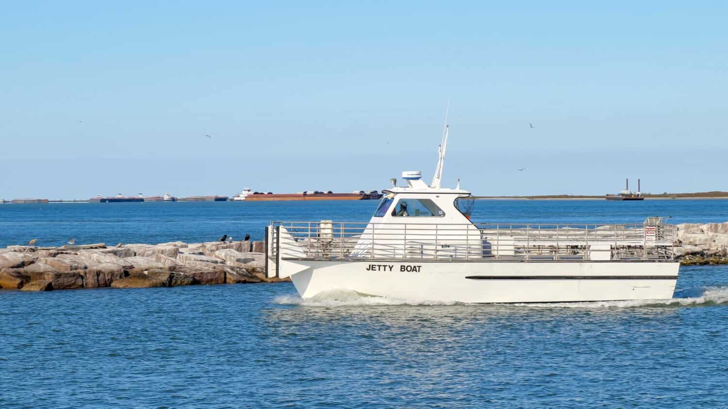 PORT ARANSAS, TX - 27 FEB 2020: La barca del molo lascia l'ingresso del porto turistico in una giornata di sole mentre va a recuperare i passeggeri dall'isola di San Jose.