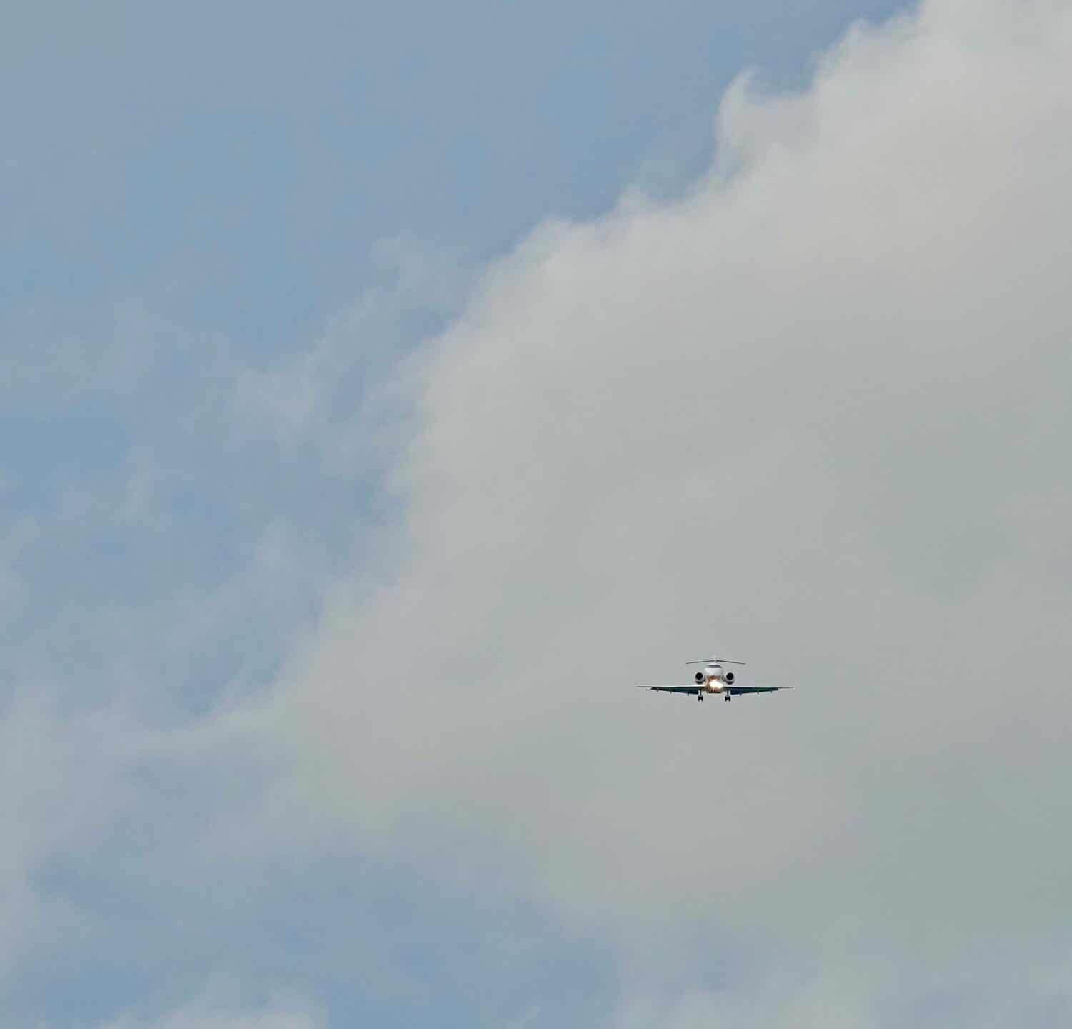                                                               Aeroplano in arrivo per un atterraggio con nuvole e cielo sullo sfondo