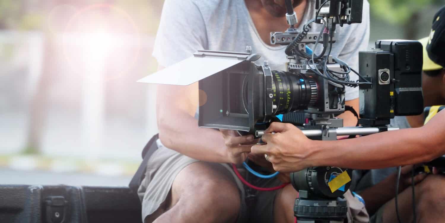 Dietro le quinte delle riprese cinematografiche o della produzione video e della troupe cinematografica con attrezzatura fotografica in esterni.