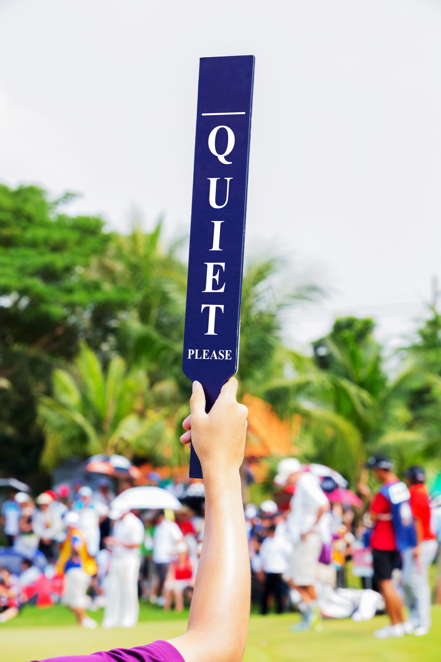 Il volontario tiene in mano un cartello tranquillo nel torneo di golf