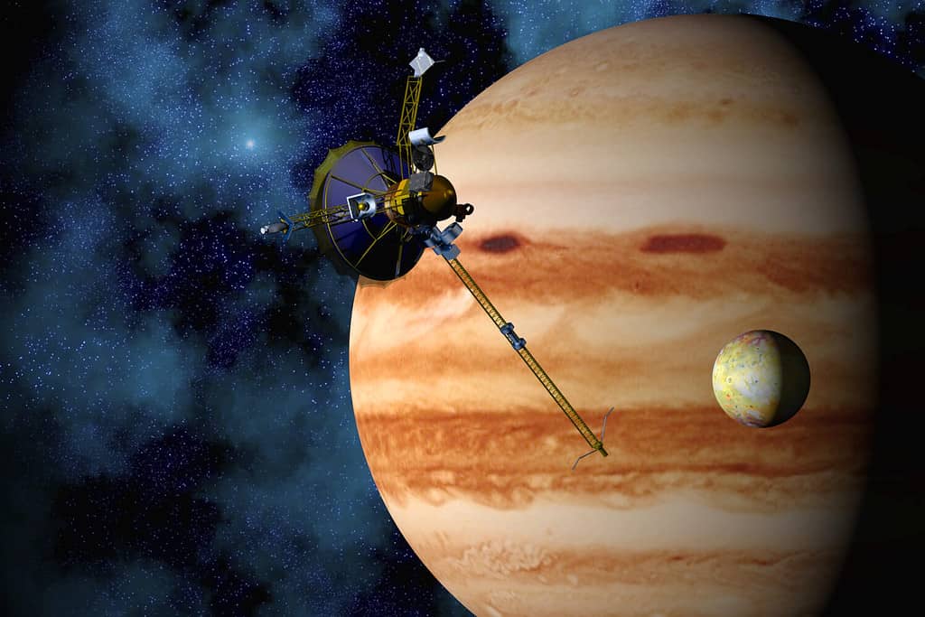 Giove, Io e la sonda spaziale Galileo con sfondo del campo stellare.  Immagine 3D generata al computer.