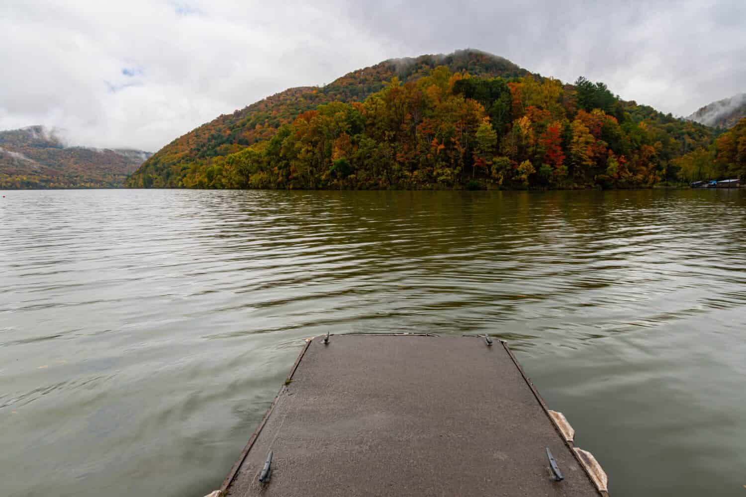Molo di pesca sul fiume Bluestone circondato da caduta di foglie e montagne, Bluestone State Park, West Virginia, USA