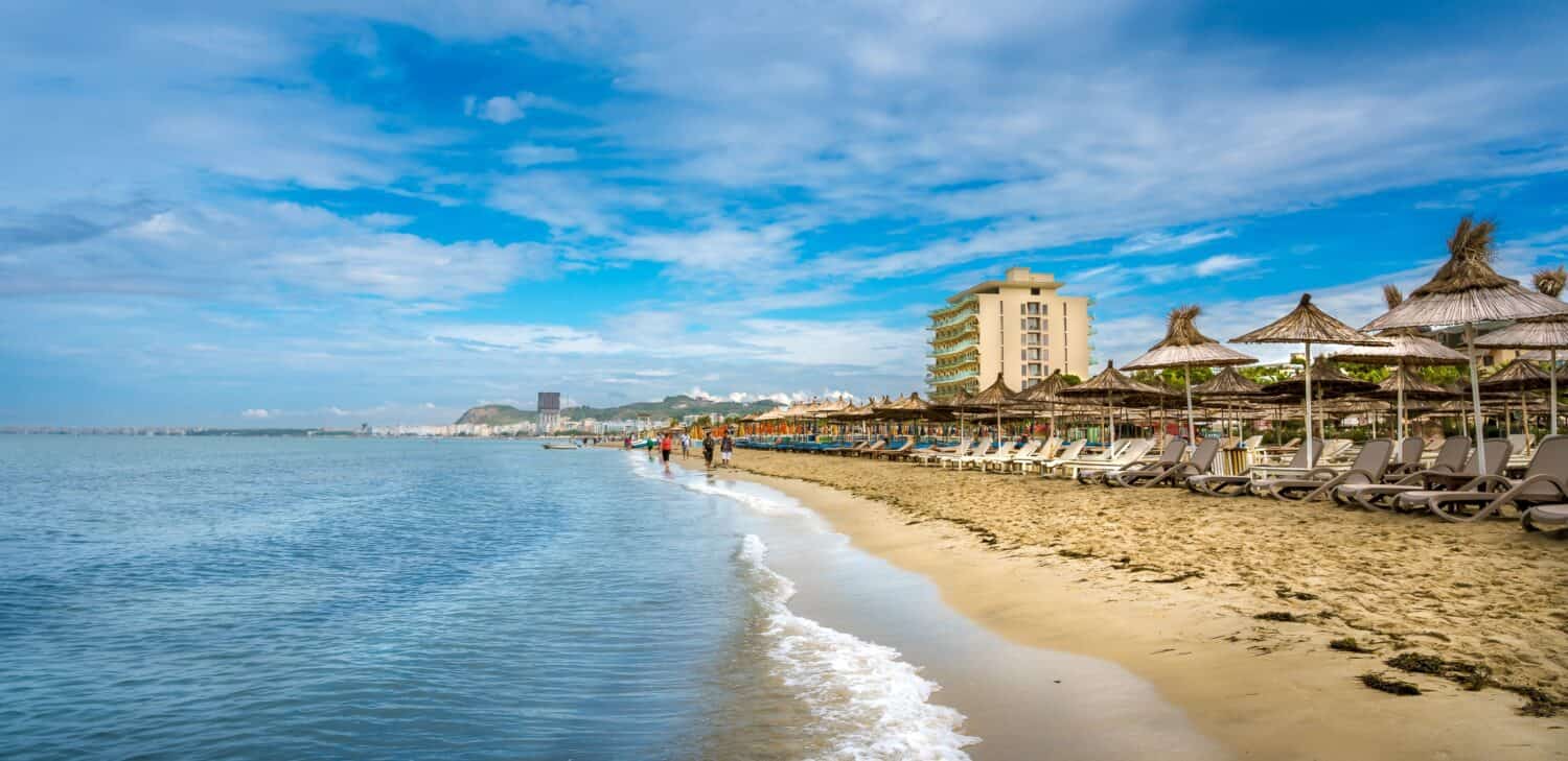 Golem, Durazzo, ALBANIA.  Litorale della spiaggia con ombrelloni in paglia.  Un cielo blu sul mare Adriatico.