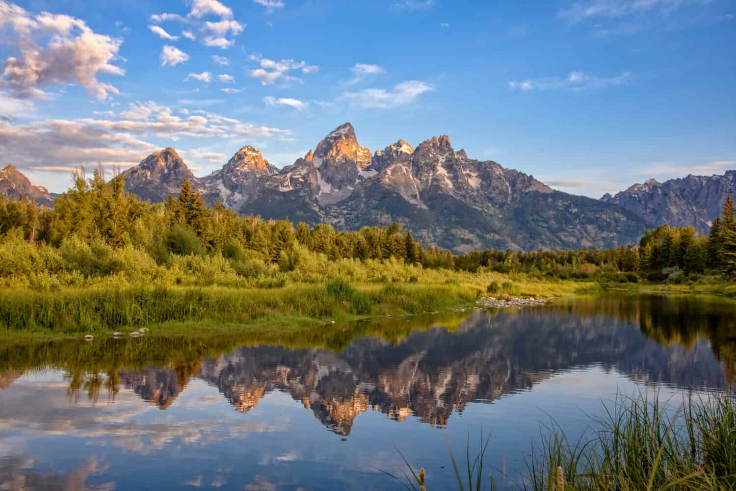 Approdo di Schwabacher, Jackson Hole, Wyoming.  Le montagne del Grand Teton si vedono all'alba riflesse nell'acqua calma del fiume Snake.