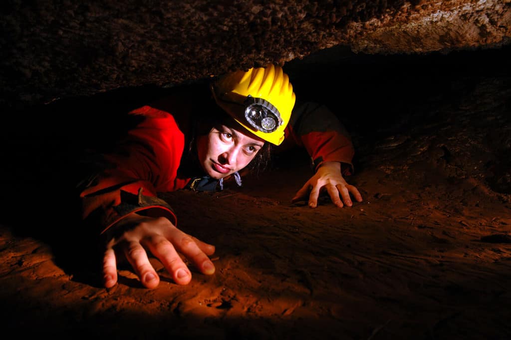 Uno stretto passaggio in una grotta con un esploratore di grotte