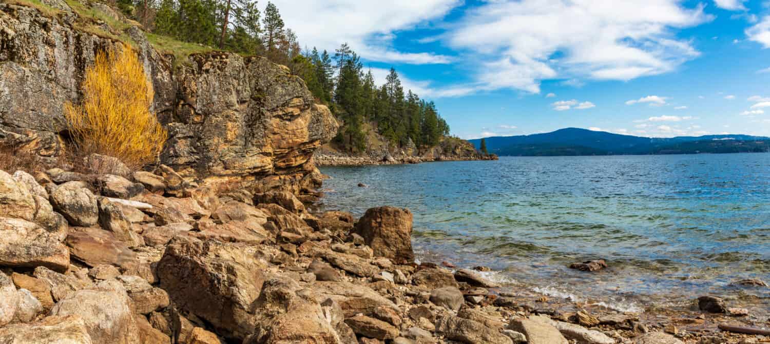 Spiaggia rocciosa sul lago Coeur d'Alene con sfondo litorale