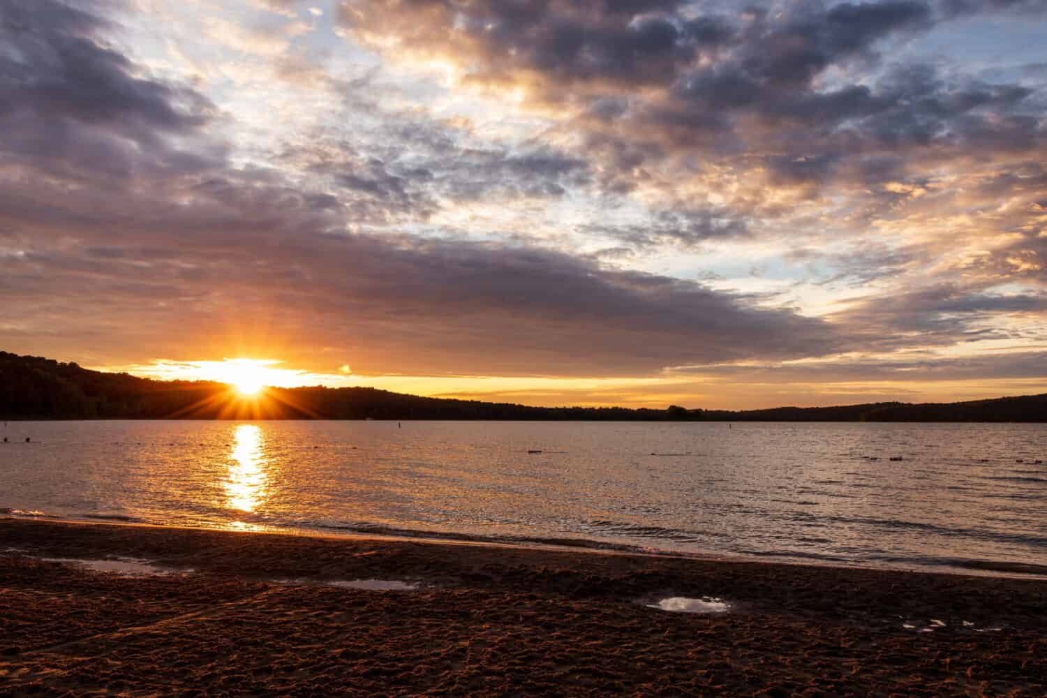 Tramonto con cielo nuvoloso visto dalla riva del lago Patoka 