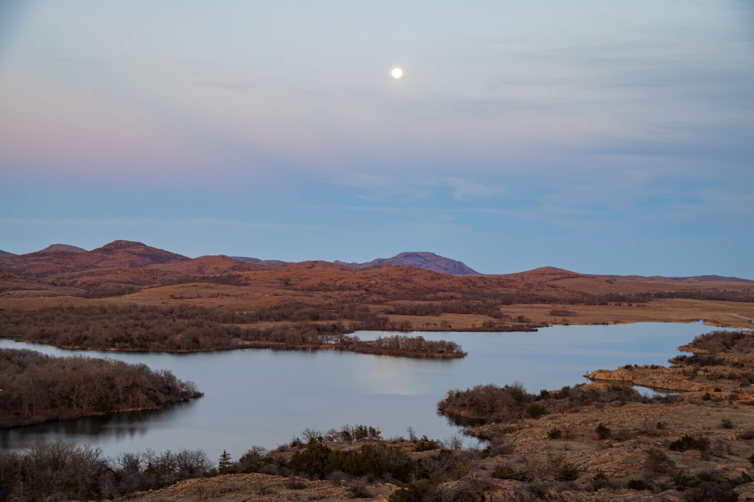 Paesaggio al tramonto con la luna piena nel Wichita Mountains National Wildlife Refuge in Oklahoma