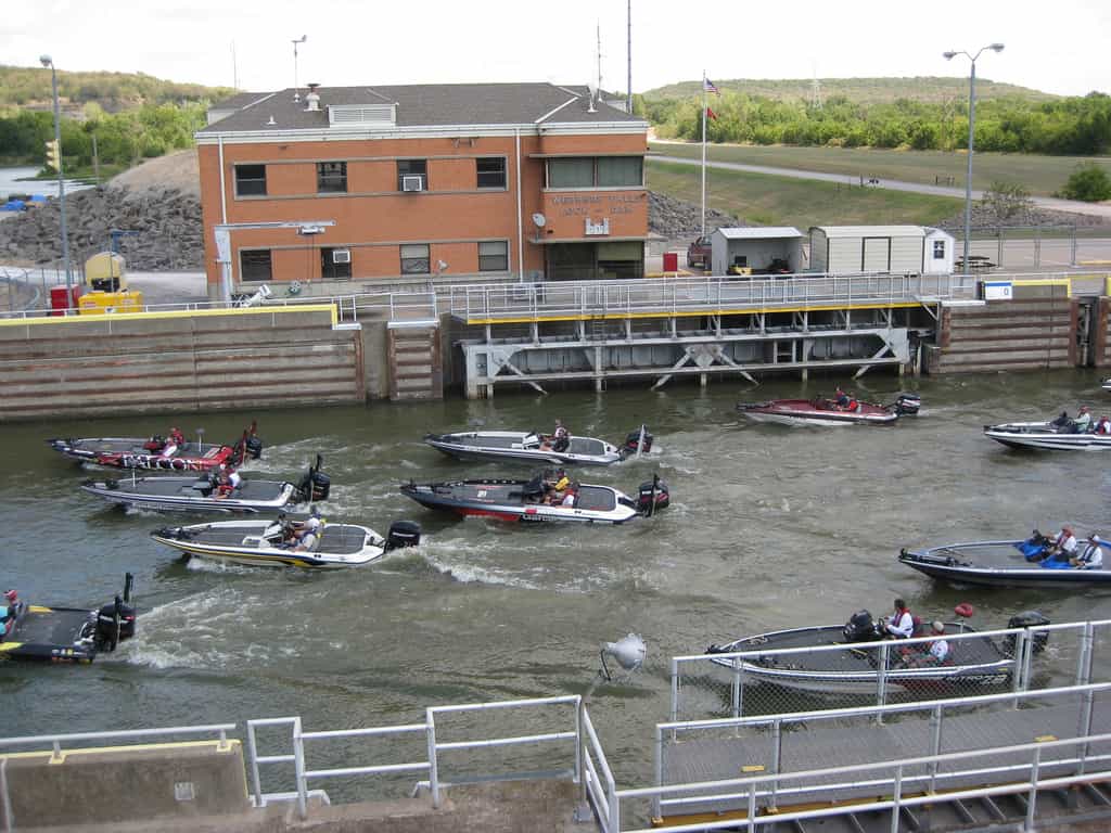 Il pescatore che partecipa al torneo di pesca professionale del Bassmaster's Central Open si chiude attraverso Webbers Falls Lock and Dam sulla strada per il peso giornaliero a Three Forks Harbour Marina.