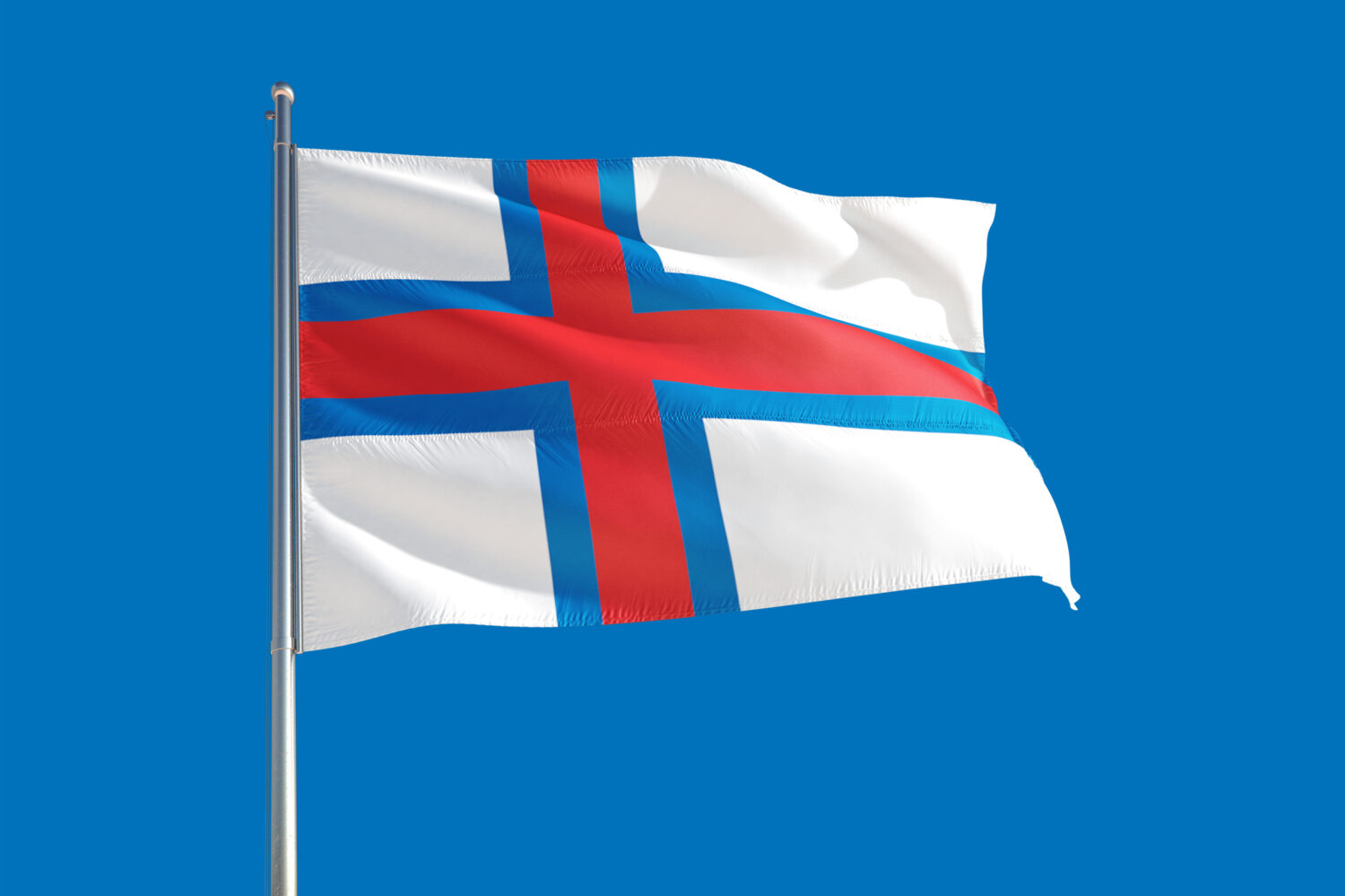 Bandiera nazionale delle Isole Faroe che sventola nel vento su un cielo blu profondo.  Tessuto di alta qualità.  Concetto di relazioni internazionali.