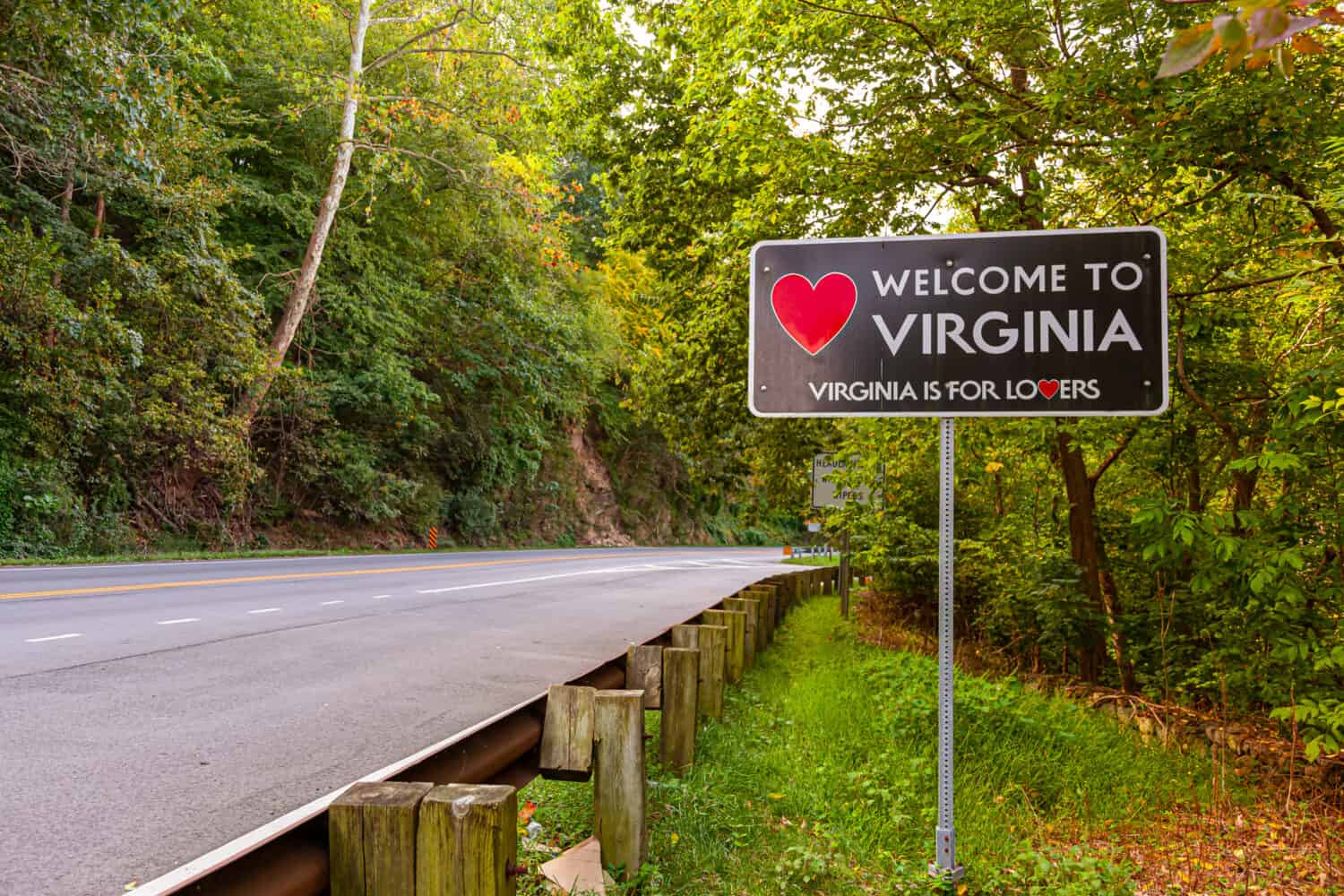 Cartello di benvenuto in Virginia situato al confine di stato del Maryland, Virginia a Purcellville, Virginia.  L'insegna nera ha una forma di cuore rosso e lo slogan 