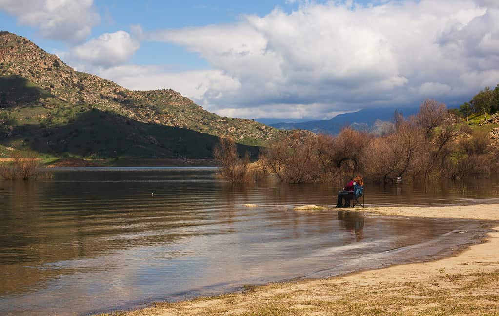 Una donna che pesca su un lago. 