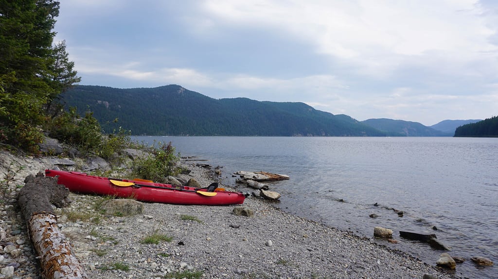 Una foto di un kayak rosso seduto sulla riva