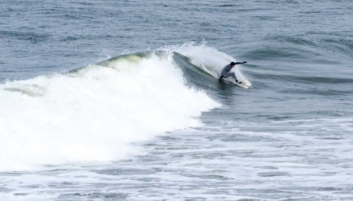 Un surfista cavalca una grande onda a Grays Harbor, Washington.