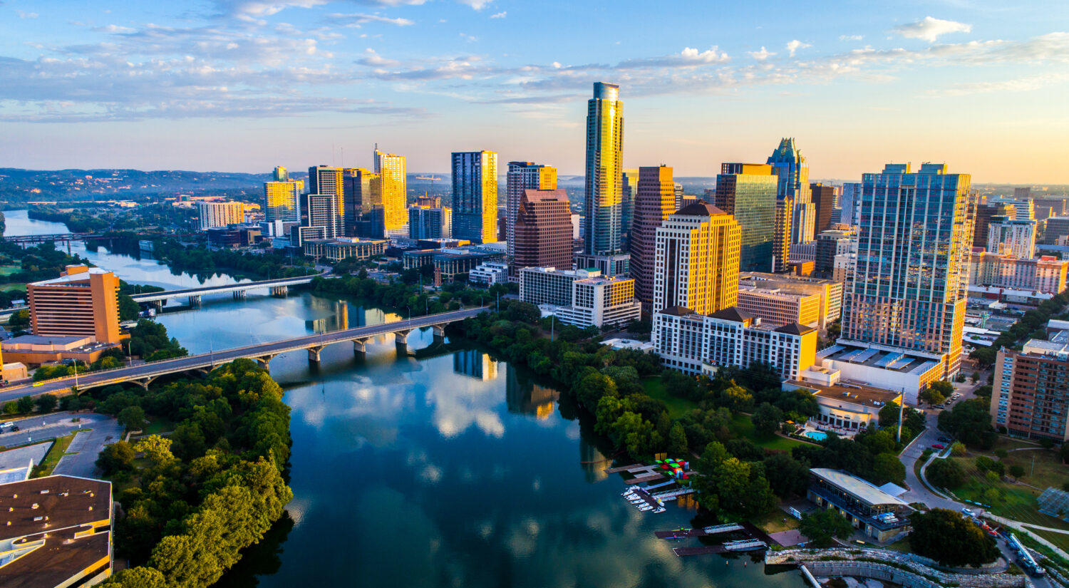 Paesaggio urbano dell'orizzonte dell'alba di Austin Texas USA sopra Town Lake o Lady Bird Lake con un'incredibile riflessione.  Grattacieli e edificio della capitale del Texas in lontananza puoi vedere l'intera città durante l'estate