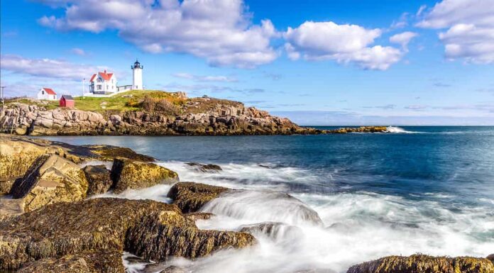 Vista di una delle migliori spiagge del Maine con il faro di Cape Neddick sullo sfondo