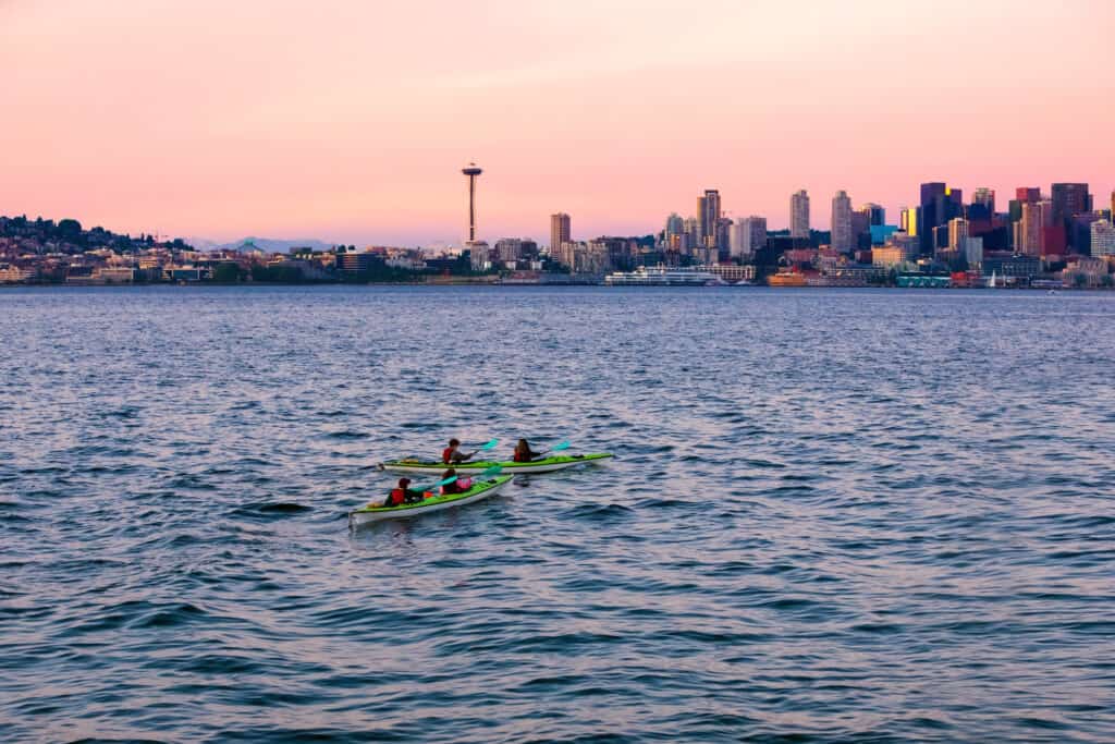 Kayak nelle acque di Puget Sound con skyline e paesaggio urbano di Seattle, WA sullo sfondo.