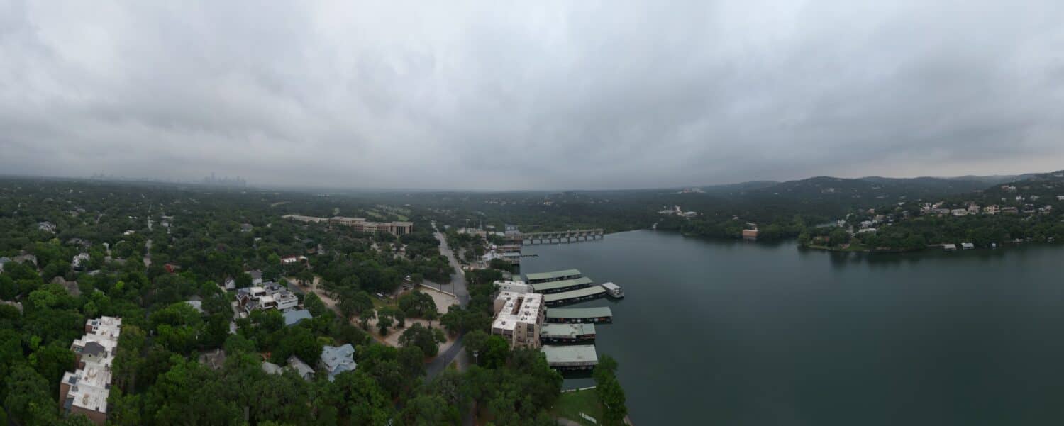 Il lago Austin, la diga Tom Miller e le colline della parte occidentale di Austin, in Texas, in una mattinata nuvolosa e nebbiosa.