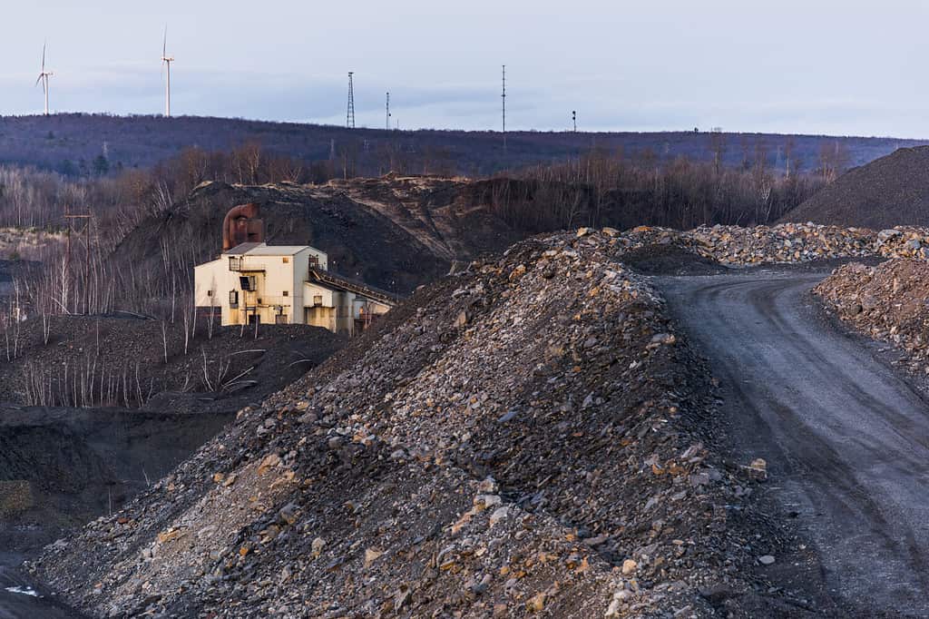 In cima a un mucchio di rifiuti di carbone in una miniera di carbone di antracite abbandonata in Pennsylvania.  Sullo sfondo un parco eolico.