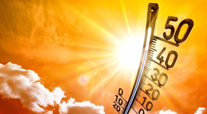 Estate calda o sfondo ondata di calore, sole splendente sul cielo arancione con termometro
