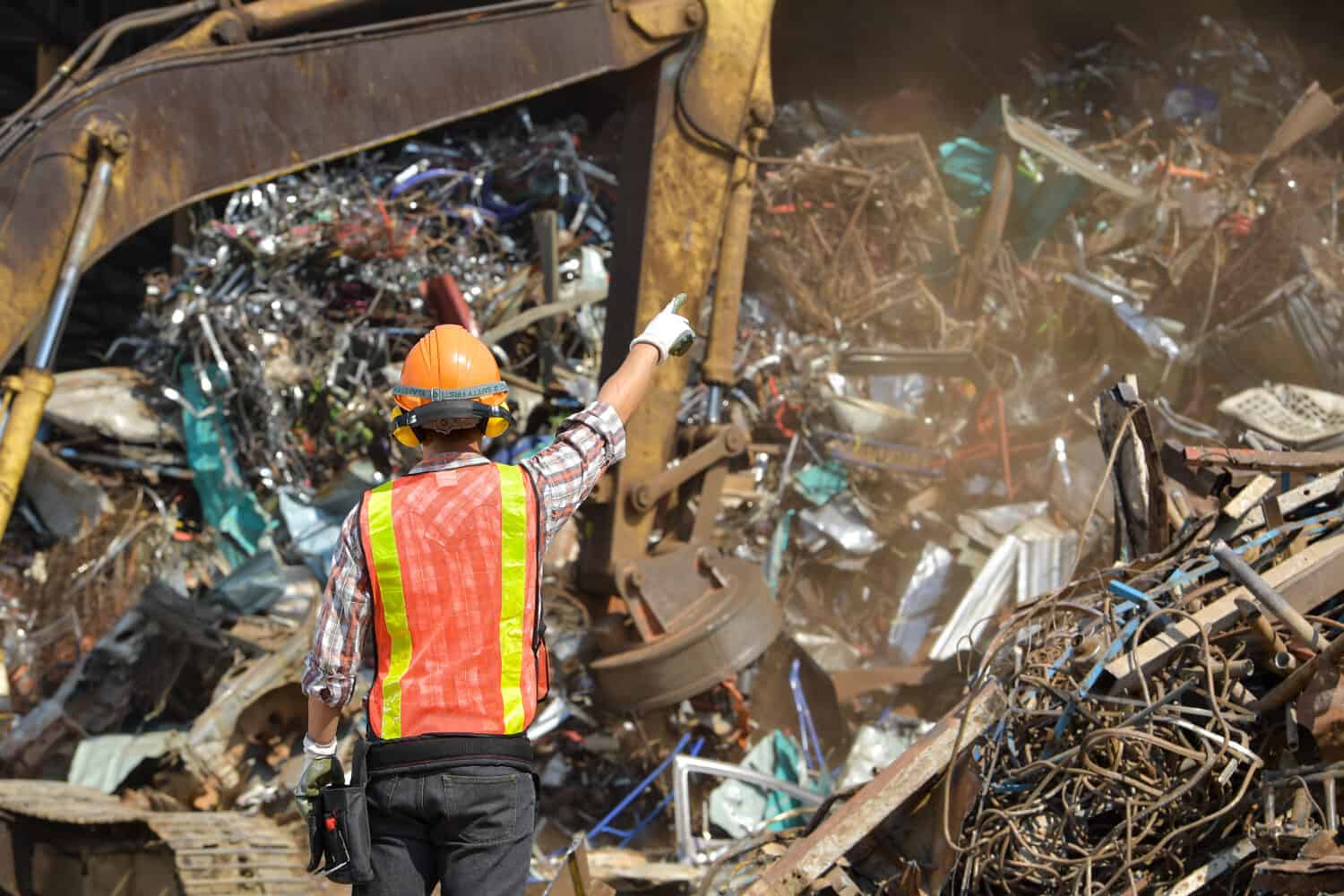 Industria del riciclaggio un lavoratore che ricicla cose nel centro di riciclaggio. Manager e lavoratore manuale in discarica di metalli