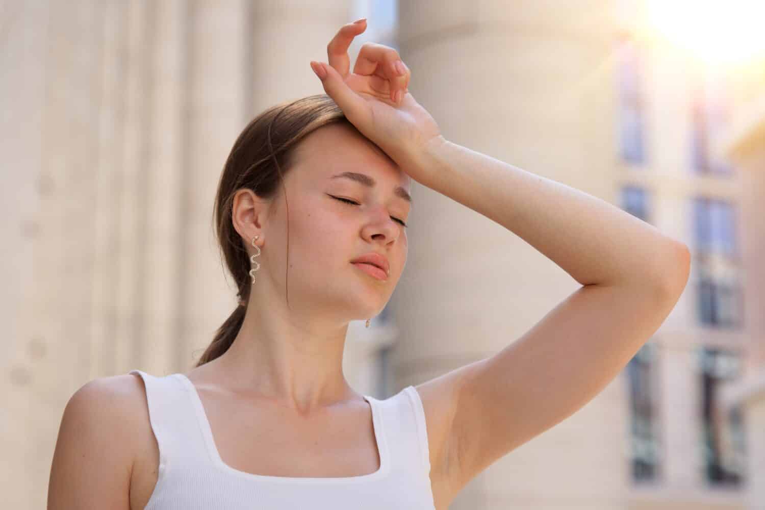 ritratto di donna stanca malata esausta, bella ragazza soffre di caldo colpo di calore estivo, sole, giornata calda, sudata e assetata, temperatura elevata.  Sensazione di malessere, malessere