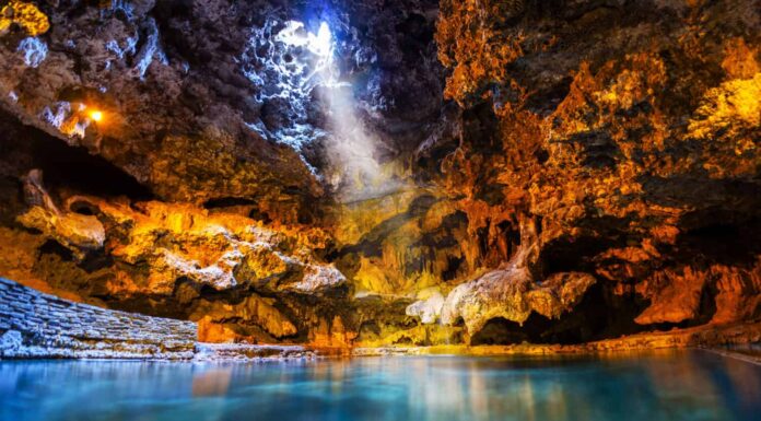 Un raggio di luce risplende attraverso un'apertura nella grotta sotterranea sulle acque termali del Cave and Basin National Historic Site, il luogo di nascita dei parchi nazionali del Canada a Banff. 