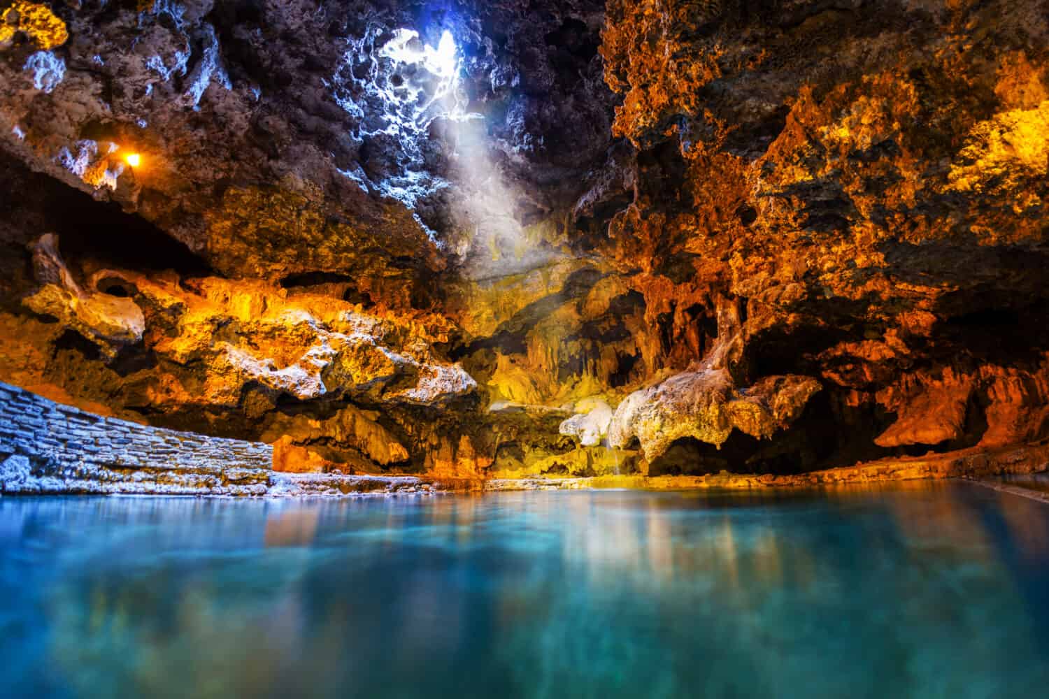 Un raggio di luce risplende attraverso un'apertura nella grotta sotterranea sulle acque termali del Cave and Basin National Historic Site, il luogo di nascita dei parchi nazionali del Canada a Banff. 