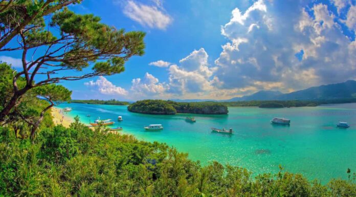 Scenario della baia di Kabira sull'isola di Ishigaki, prefettura di Okinawa, Giappone. Sabbia bianca, acque turchesi e fitta vegetazione, questa baia fa parte del Parco Nazionale Iriomote Ishigaki.  Luogo di bellezza paesaggistica.