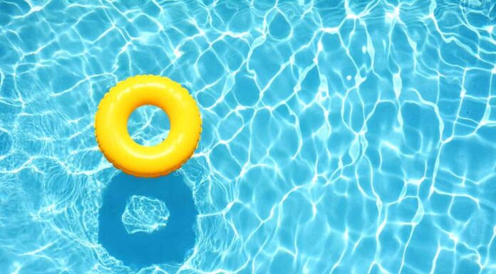 Galleggiante giallo per piscina, anello galleggiante in una rinfrescante piscina blu