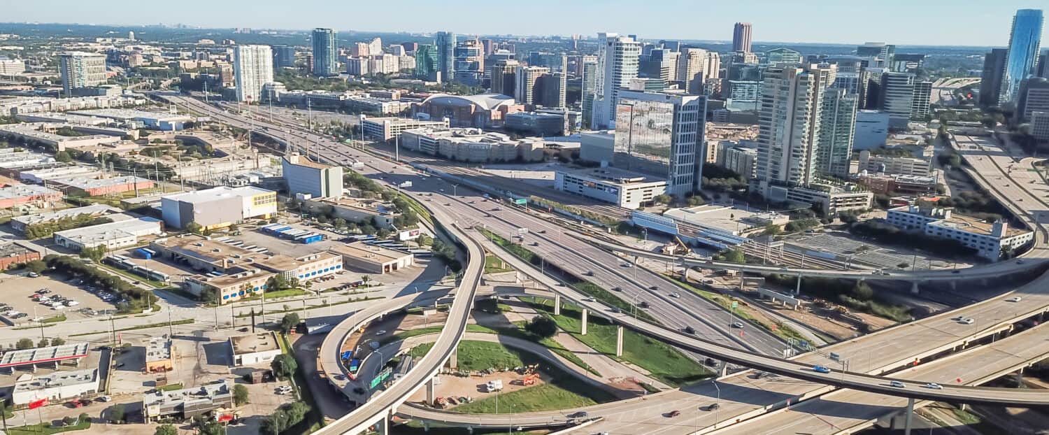 Interscambio della pila dell'autostrada di vista aerea di panorama ed edifici del centro di Dallas sotto il cielo blu della nuvola.  Woodall Rodgers Freeway, Stemmons Freeway, Interstate 35E (I-35E)