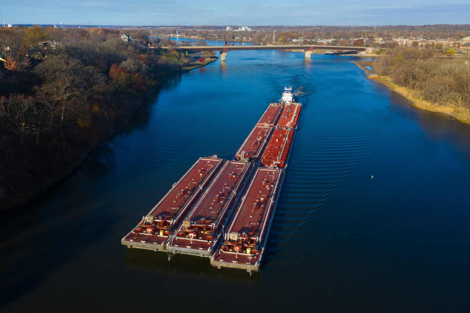 Una chiatta rossa spedisce il carico lungo il fiume Illinois vicino a Ottawa, Illinois.  Fotografia aerea tramite drone.