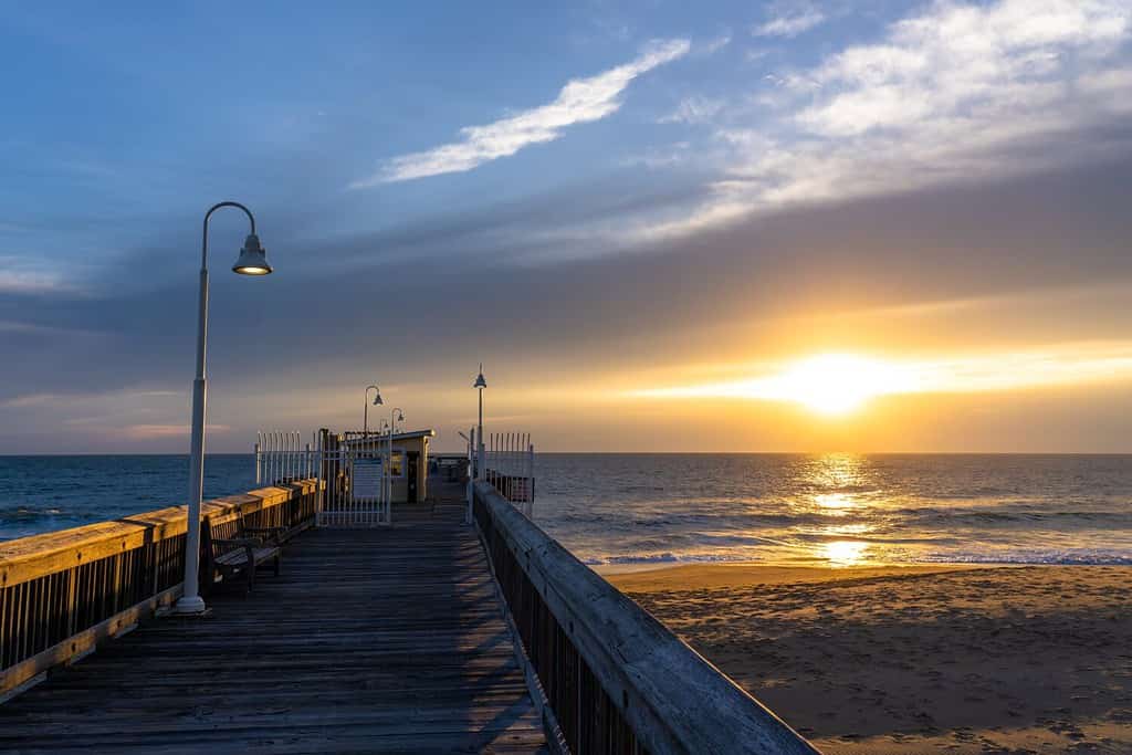 Luce dell'alba mattutina che fa capolino tra le nuvole al Sandbridge Fishing Pier Little Island Park a Virginia Beach