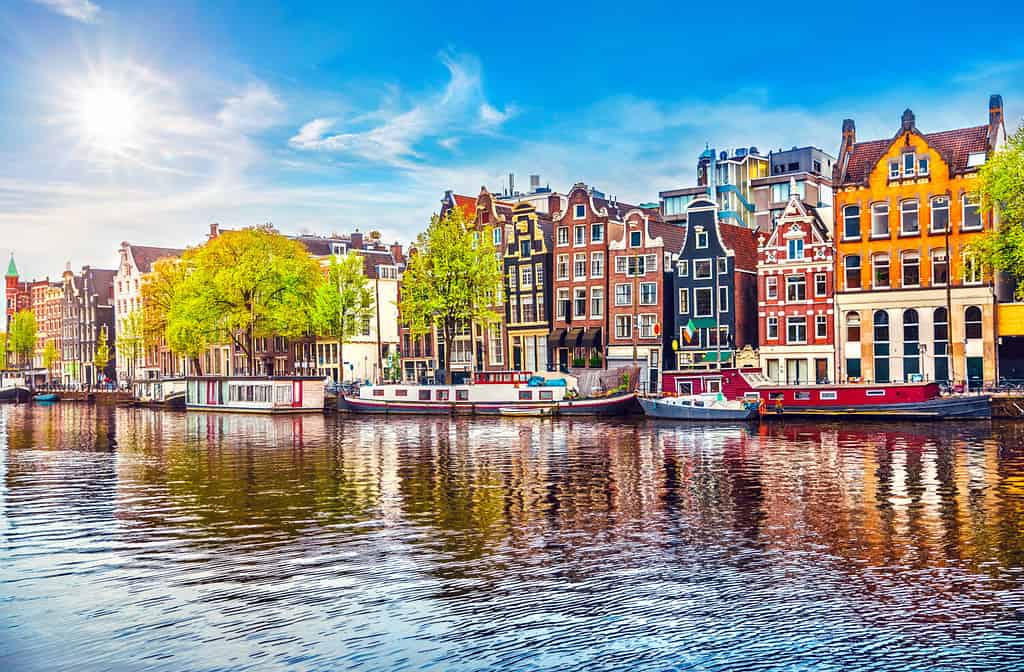 Case danzanti di Amsterdam Paesi Bassi sul fiume Amstel, punto di riferimento nel paesaggio primaverile della vecchia città europea.