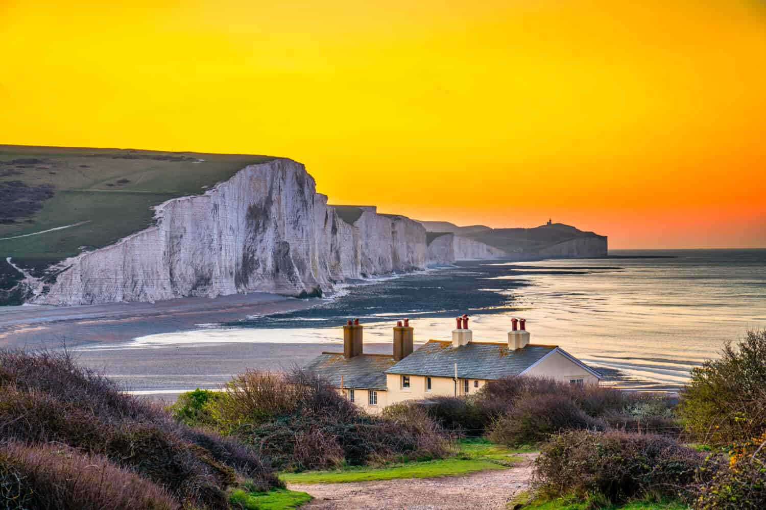 I Coast Guard Cottages e Seven Sisters Chalk Cliffs all'alba nel Sussex, Inghilterra, Regno Unito