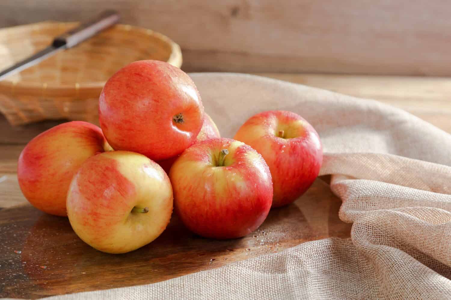 Gruppo di Fresh Jazz Apple su sfondo di tavola di legno, concetto di frutta.