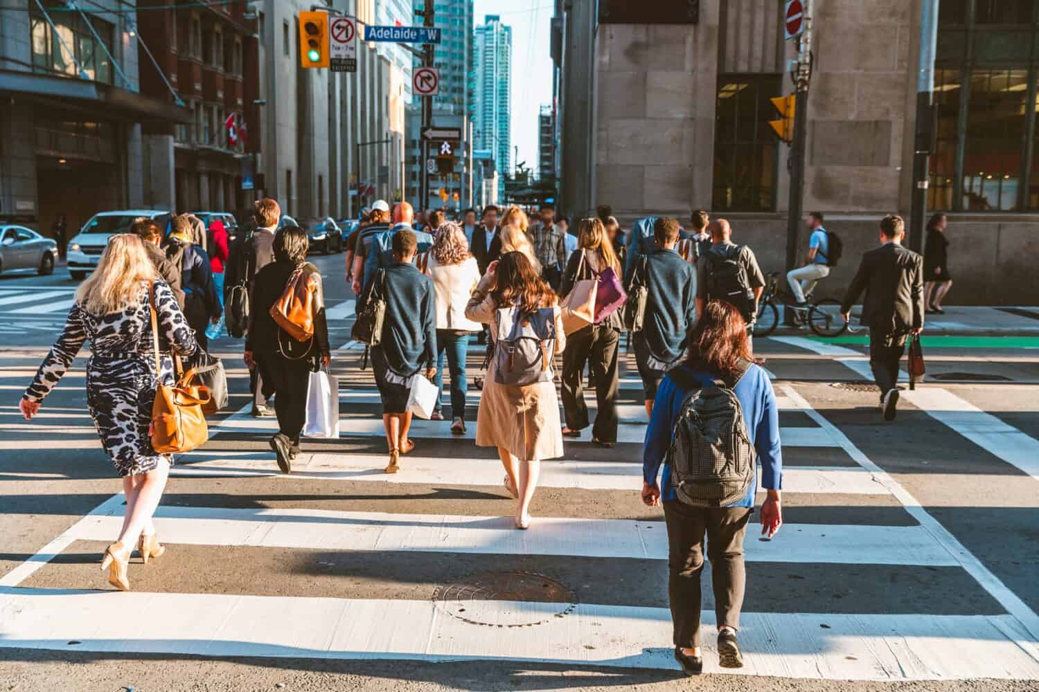 Folla di persone irriconoscibili che attraversano la strada sulla zebra del semaforo nella città di Toronto all'ora di punta - Stile di vita in una grande città del Nord America