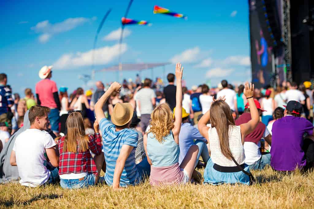 Adolescenti, festival musicale estivo, seduti davanti al palco