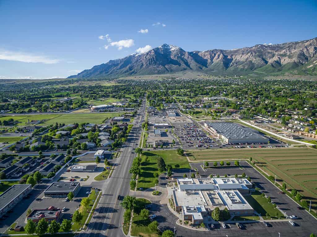 Vista aerea da un drone di Washington Blvd e del distretto commerciale di North Ogden, Utah con il Ben Lomond Peak e le Wasatch Mountains visibili sullo sfondo