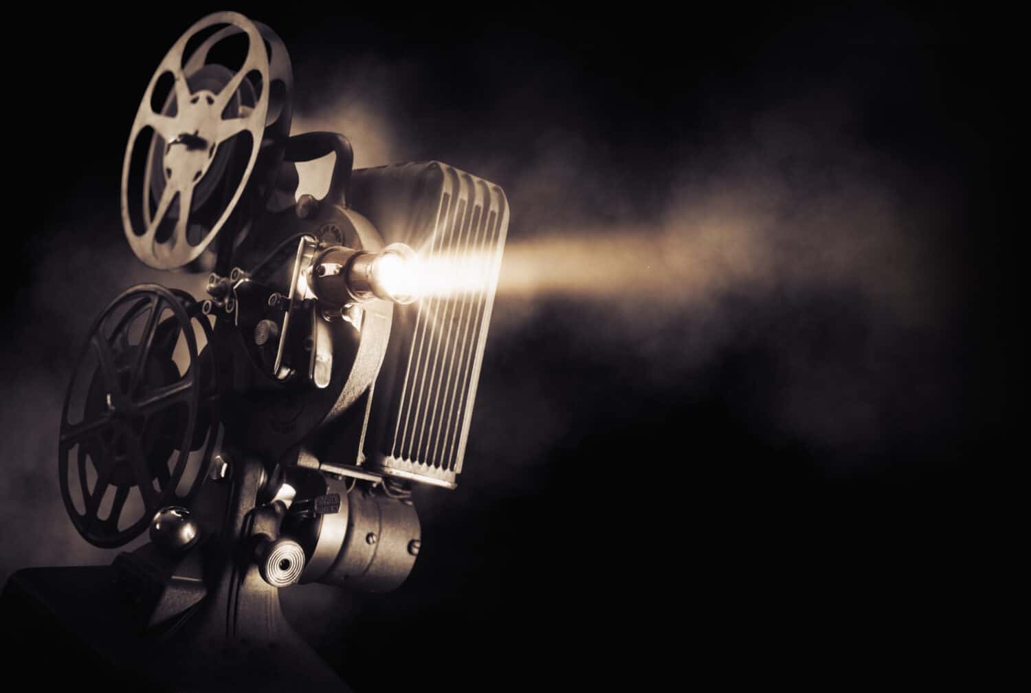 Proiettore cinematografico su sfondo scuro con fascio di luce/immagine ad alto contrasto