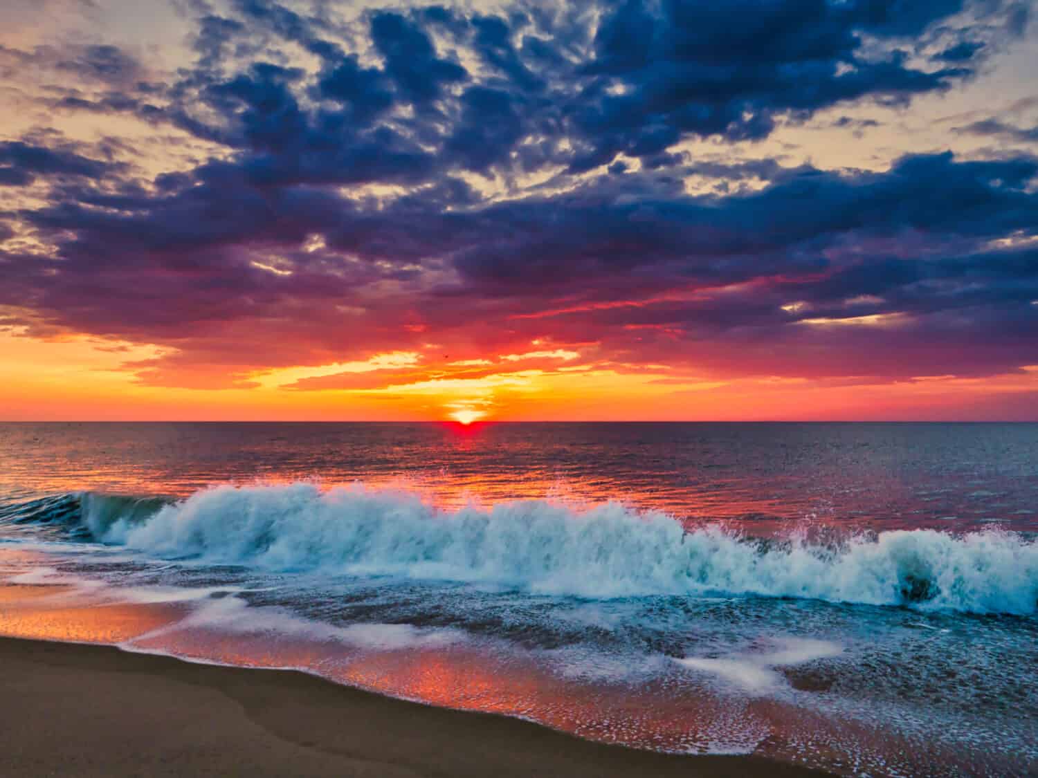 Alba dalla spiaggia di Bethany, Delaware, con spettacolare skycap e surf.