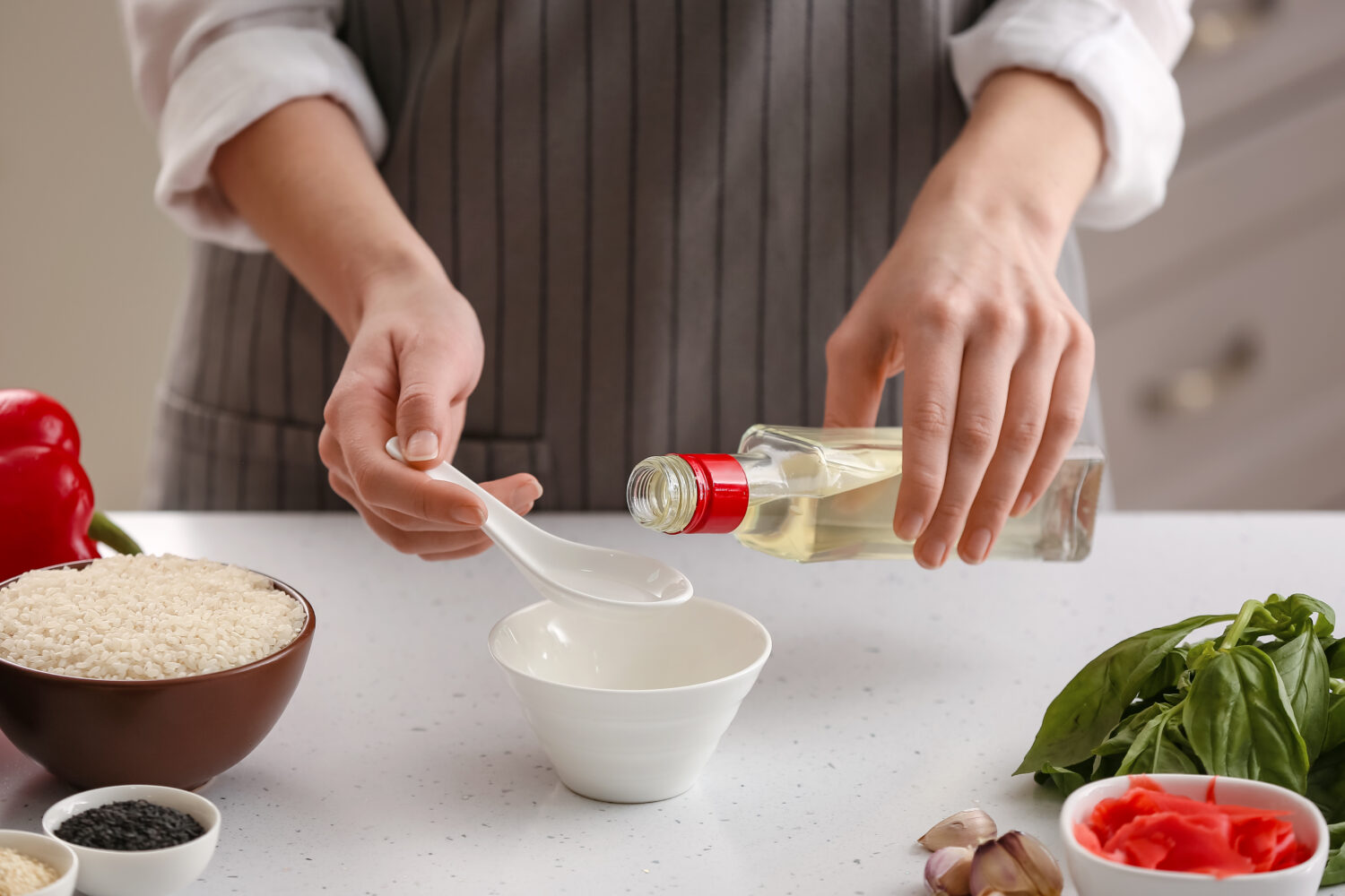 Donna che prepara salsa con aceto di riso in cucina