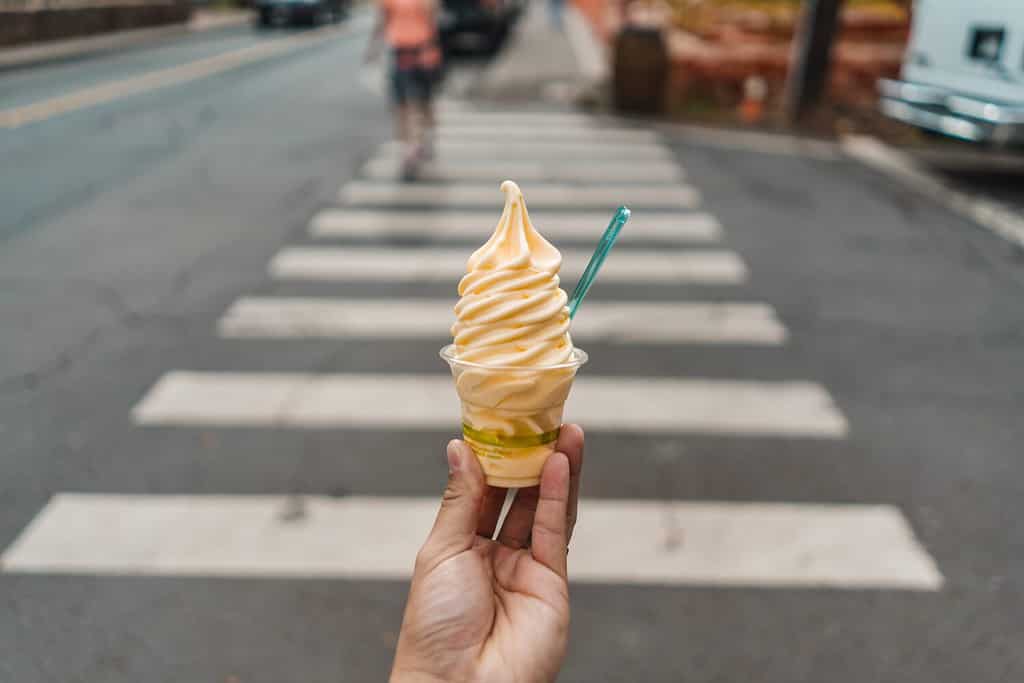 Un uomo con ananas Dole Whip Frozen Yogurt gelato su Crosswalk Street